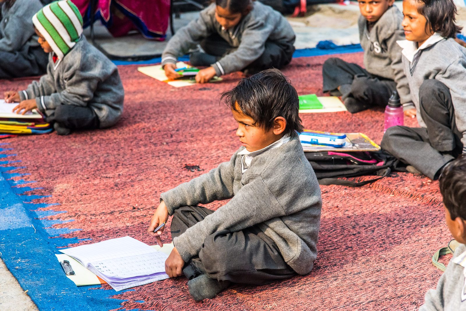 A young student writing in his notebook during class